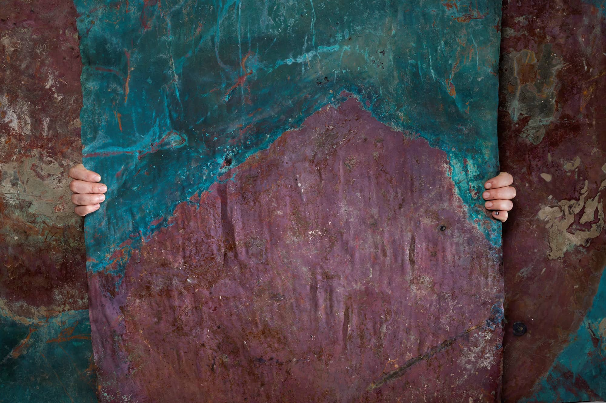 Foto van een koperplaat, vastgehouden door twee handen