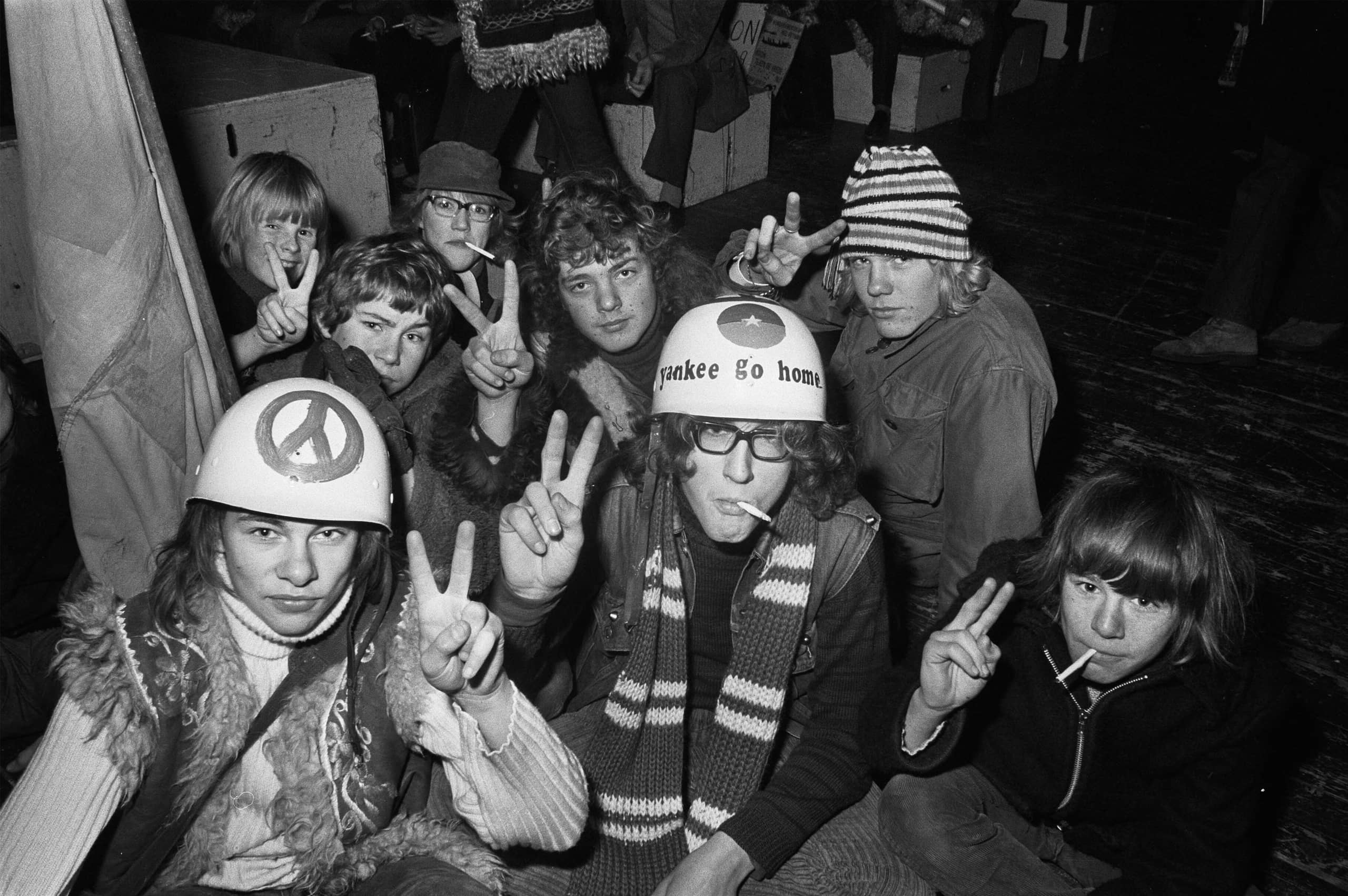 Een groep scholieren die de camera inkijken en met hun hand een peace-sign maken.