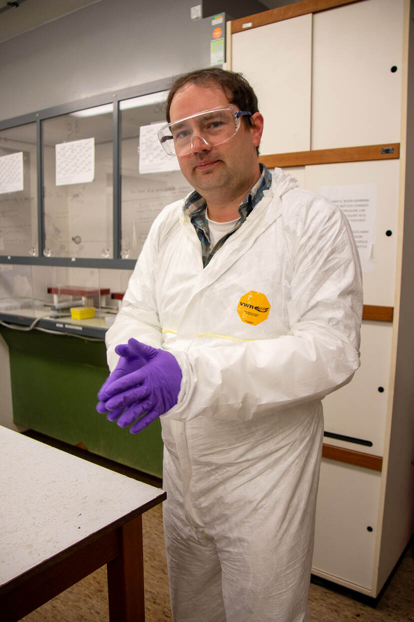 onderzoeker in beschermende kleding in laboratorium