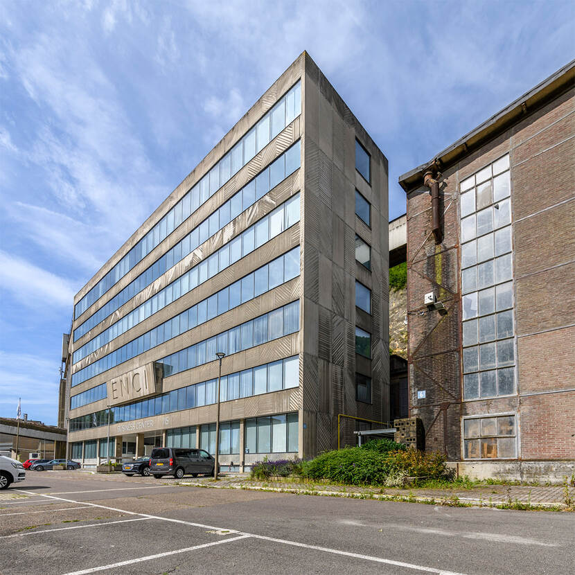 Groot gebouw met glazen ramen en op de gevel 'ENCI' in beton.