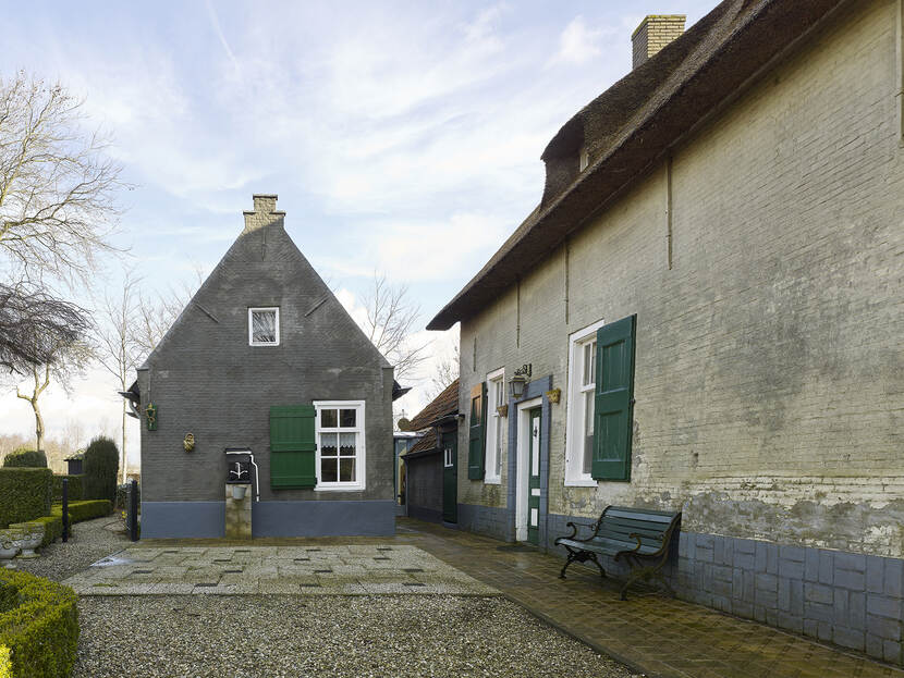 de achterzijde van Boerderij De Meeshoeve, met binnenplaats en een bankje