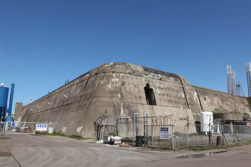 Foto van de Schnellboot- of torpedobunker in IJmuiden, een groot betonnen gebouw wat lijkt op een onderzeeboot