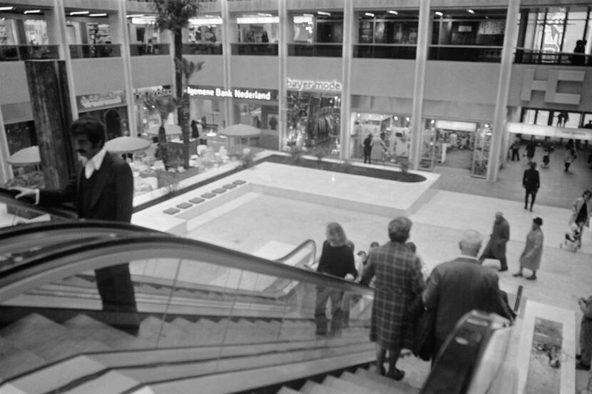 Zwart-wit foto van het winkelcentrum met een roltrap en winkels