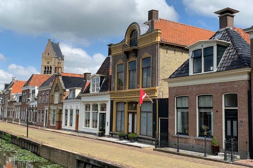 Foto van straat met historische huizen en gracht in Bolsward, Friesland